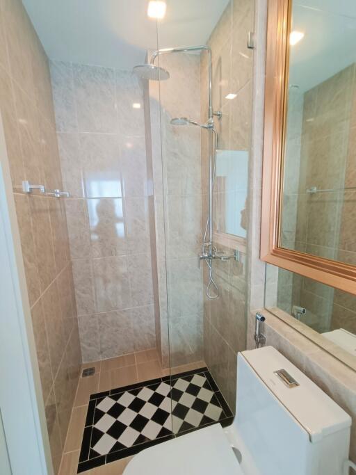 Modern bathroom with glass shower partition and checkered tile design