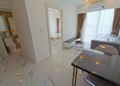 Modern living area with marble floors, a view to a bedroom, and access to a bathroom