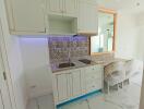 Modern kitchen with white cabinets and a tiled backsplash