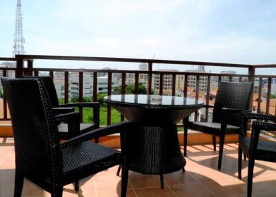 Balcony with table and chairs overlooking cityscape