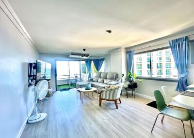 Spacious living room with a large window and balcony access