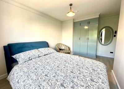 Spacious bedroom with patterned bedding and furniture