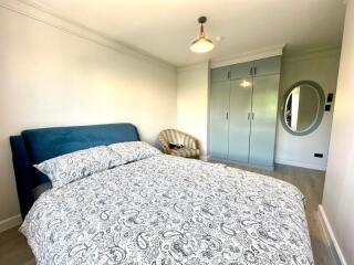 Spacious bedroom with patterned bedding and furniture