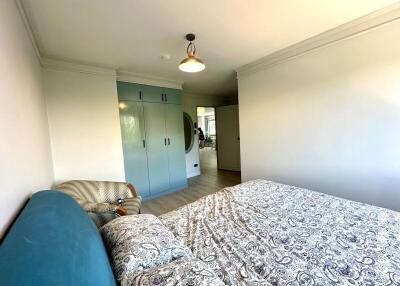 Bright, modern bedroom with blue accents and large wardrobe