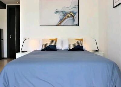 Modern bedroom with blue bedding and abstract artwork