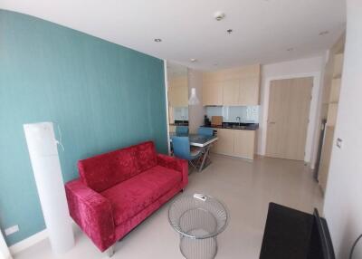 Modern living room with red sofa and adjoining kitchen