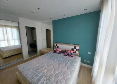 Bedroom with bed, green accent wall, and window