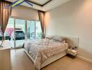 modern bedroom with large bed and glass doors to patio