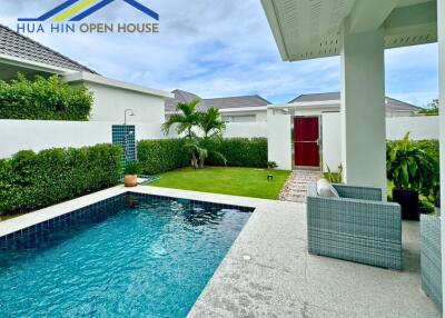 Outdoor pool area with seating and garden