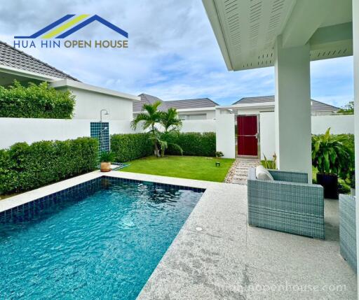 Outdoor pool area with seating and garden