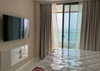 Bedroom with ocean view and wall-mounted TV