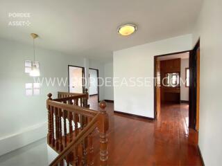 Bright upper hallway with wooden flooring and staircase