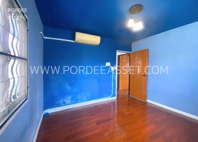 Bedroom with blue walls and wooden floor