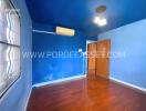 Bedroom with blue walls and wooden floor