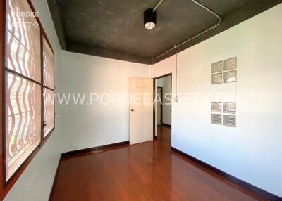 Bedroom with wooden flooring and a semi-modern ceiling lamp fixture