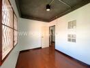 Bedroom with wooden flooring and a semi-modern ceiling lamp fixture