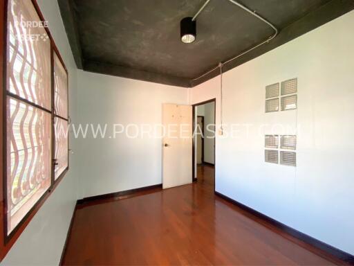 Bedroom with wooden flooring and a semi-modern ceiling lamp fixture