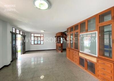 Spacious living room with built-in wooden cabinets and large windows