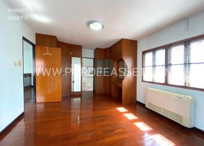 Spacious bedroom with wooden floors, built-in wooden closets, and ample natural light