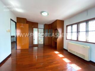 Spacious bedroom with wooden floors, built-in wooden closets, and ample natural light