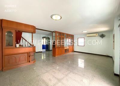 Spacious living room with built-in wooden cabinetry and stairway