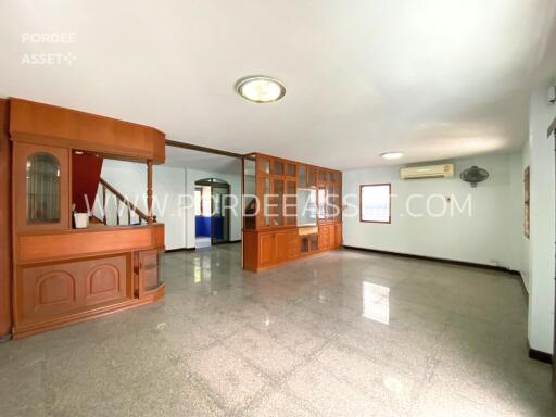 Spacious living room with built-in wooden cabinetry and stairway