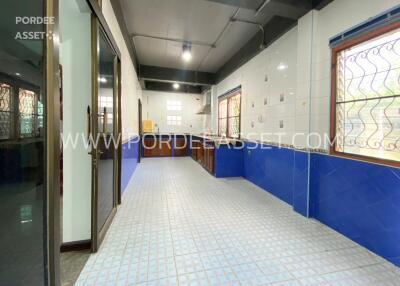 Modern kitchen with blue and white tile design, large windows and ample natural light