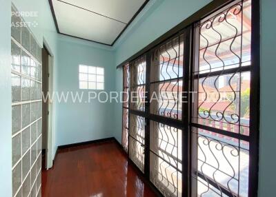 Enclosed sunroom with large windows and wooden flooring