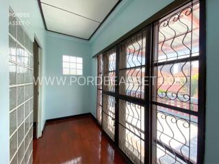 Enclosed sunroom with large windows and wooden flooring