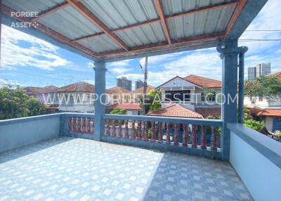 Spacious balcony with tiled flooring and a covered roof.