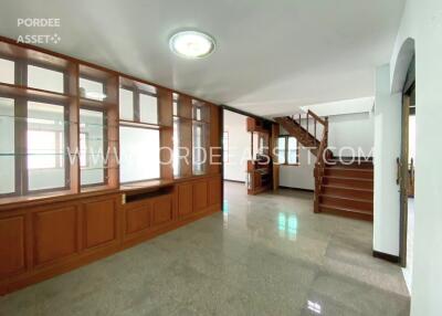 Spacious living area with wooden built-in cabinet and staircase