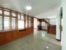 Spacious living area with wooden built-in cabinet and staircase