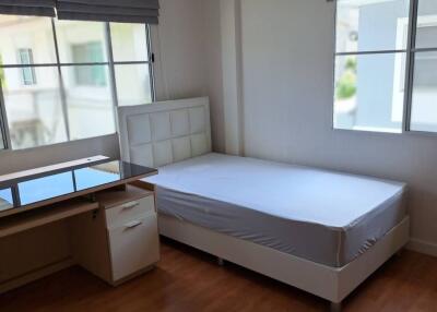 A bedroom with a single bed and desk