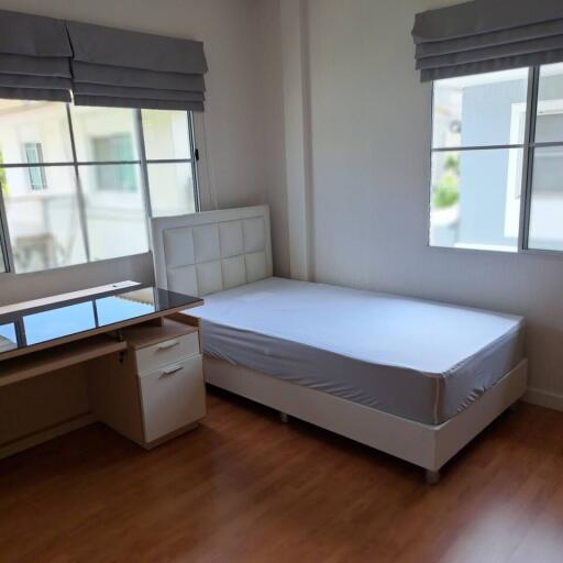 A bedroom with a single bed and desk