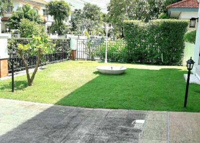 spacious backyard with green lawn and paved area