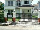 Front view of a two-story house with a gated entrance