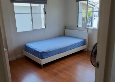 Simple bedroom with a single bed and wooden floor