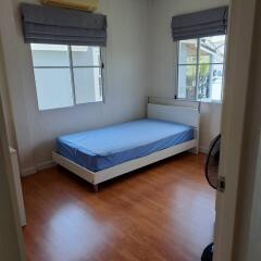 Simple bedroom with a single bed and wooden floor