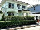 Two-story white house with garden fence