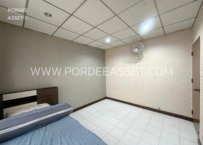 Bedroom with bed, fan, and white-tiled floor