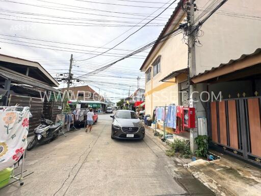 Street view with buildings, car, and laundry