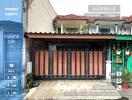 Front view of the building with a garage and gate