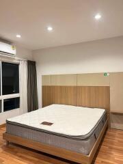 Modern bedroom with a large bed and wooden flooring