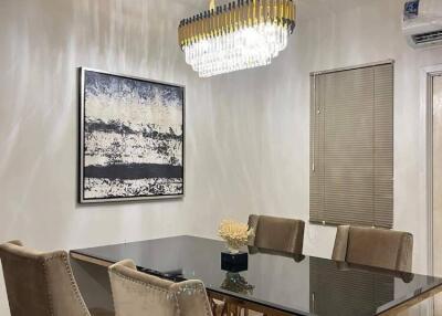 Modern dining room with elegant chandelier and glass table