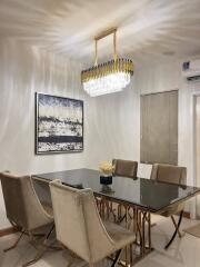 Modern dining room with elegant chandelier and glass table