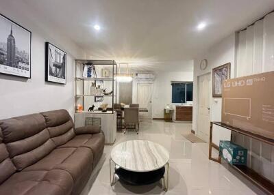 Modern living room with brown leather sofa, marble coffee table, dining area, and new LG UHD TV box