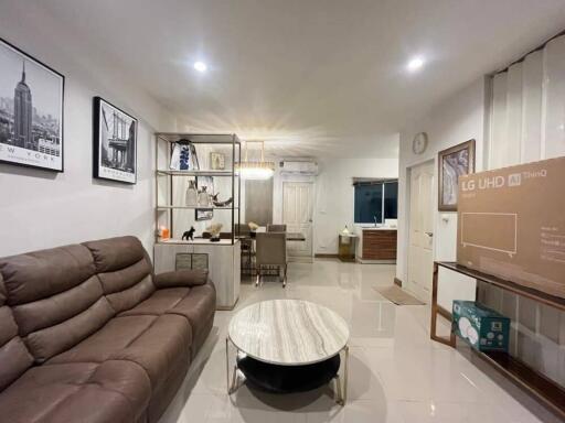 Modern living room with brown leather sofa, marble coffee table, dining area, and new LG UHD TV box