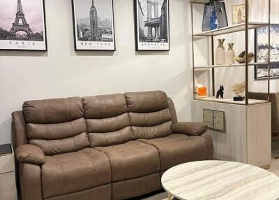 Modern living room with brown leather sofa and framed city prints