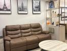 Modern living room with brown leather sofa and framed city prints