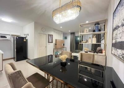 Modern dining area with an elegant chandelier and a black dining table